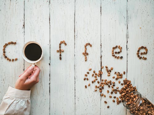 Free Word Coffee from Beans on Wooden Background Stock Photo