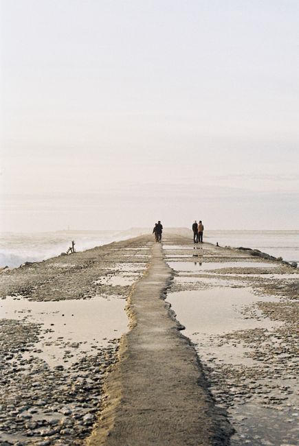 A serene walk on the breakwater in Figueira da Foz, Portugal, against a coastal backdrop.