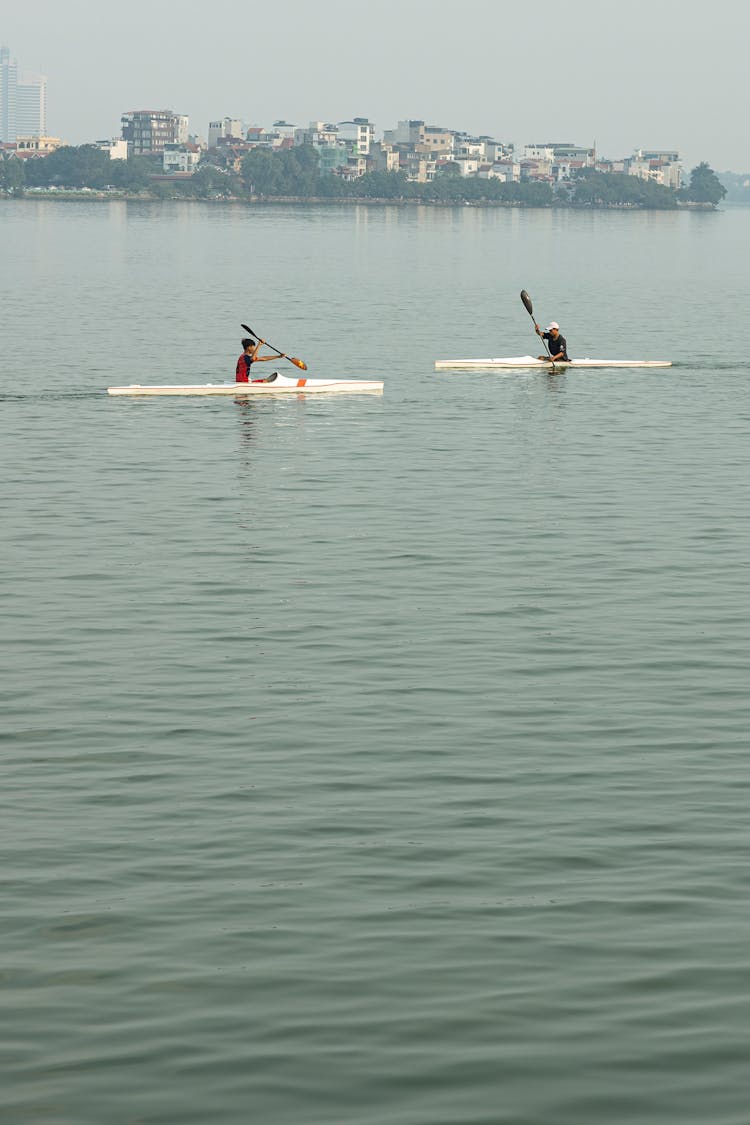 People Riding In White Kayak Boats