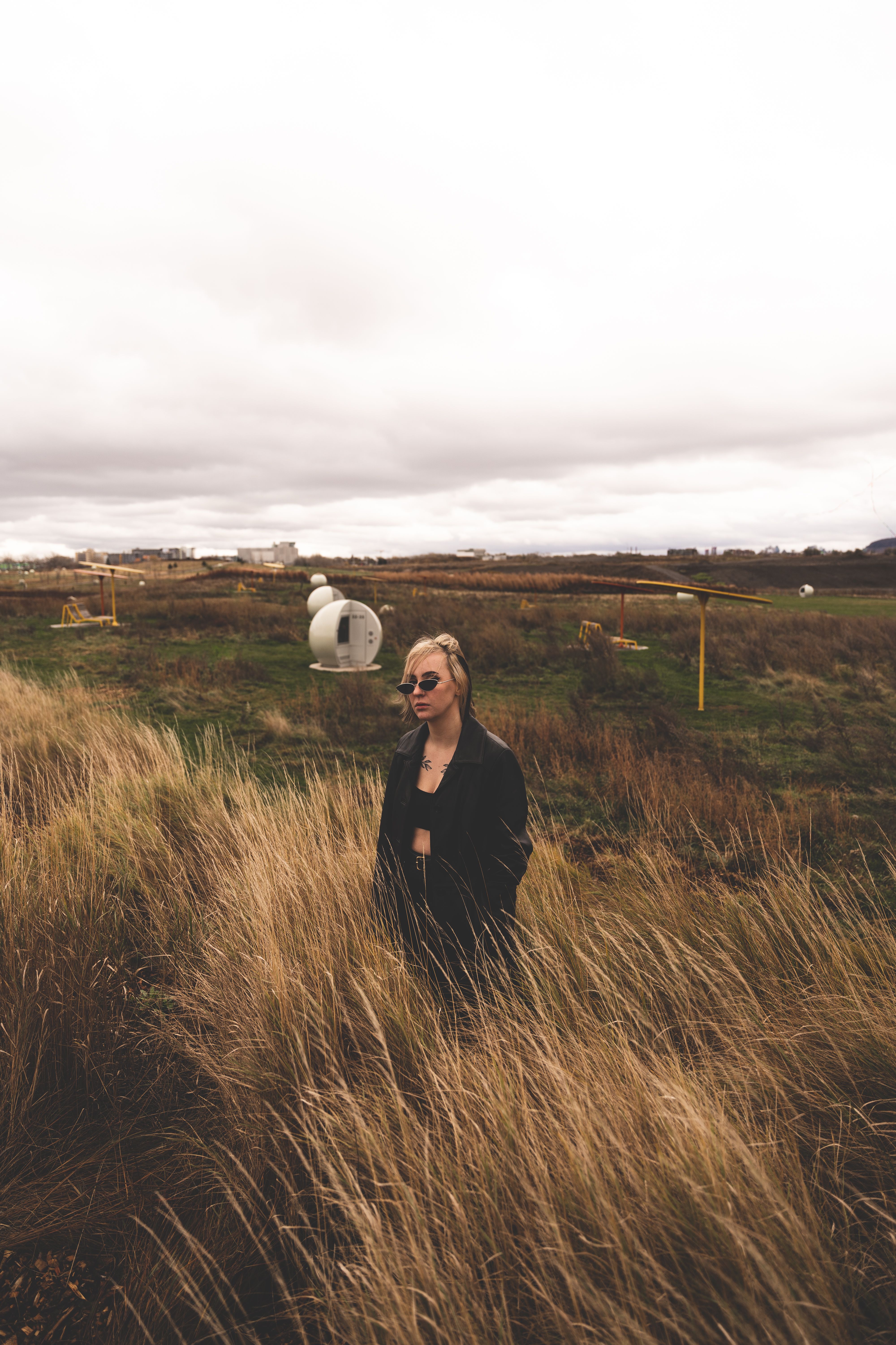 A Woman in Black Jacket Standing on Grass Field · Free Stock Photo