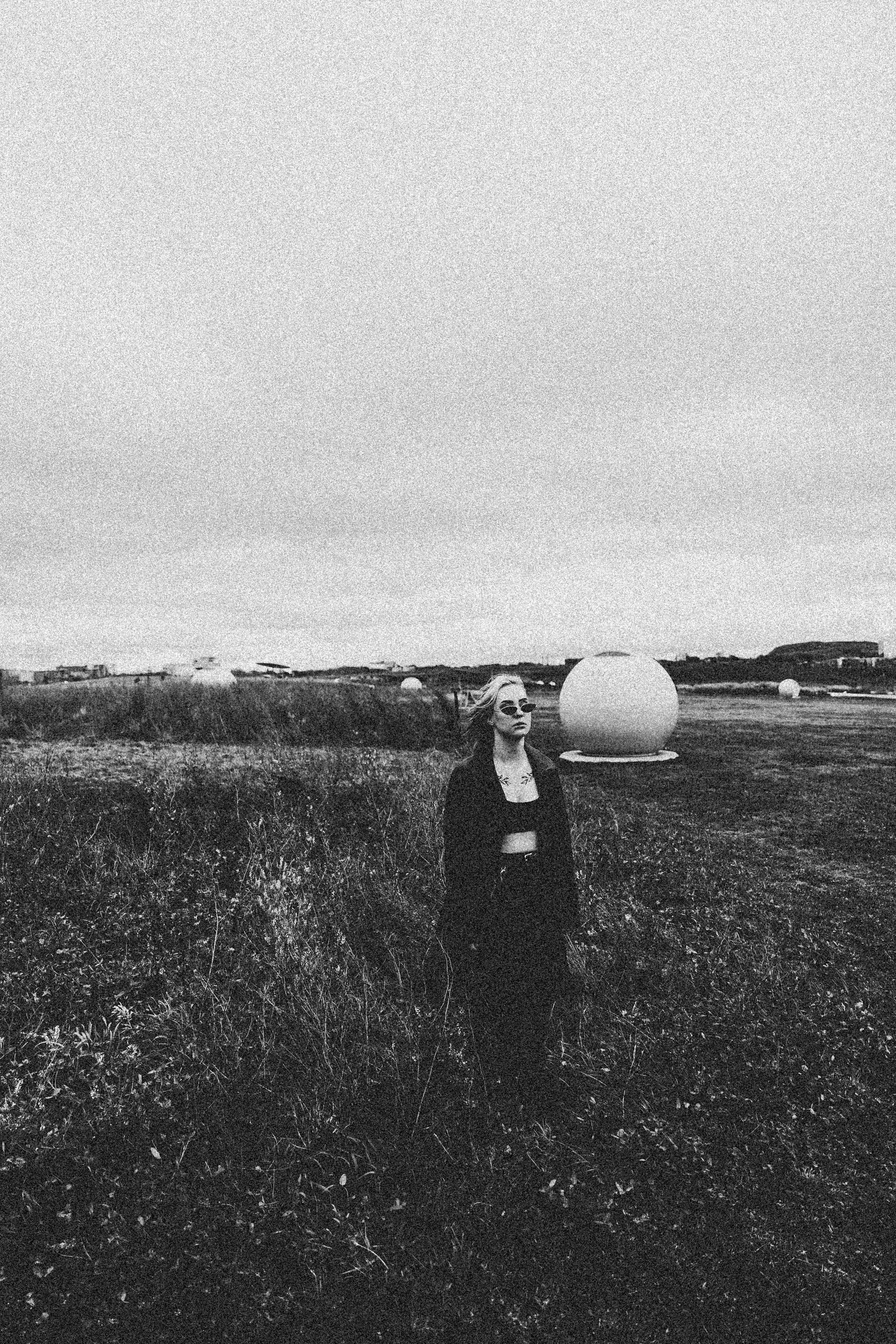 Grayscale Photo of a Woman in a Grass Field · Free Stock Photo