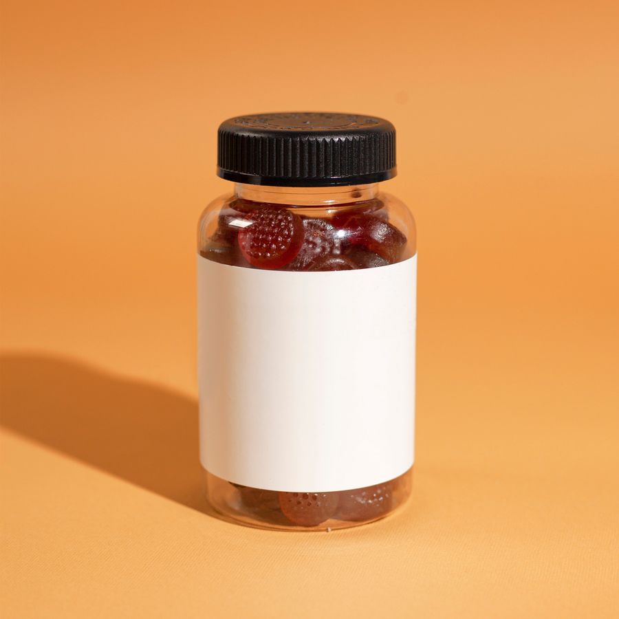 A single jar of gummies on an orange background