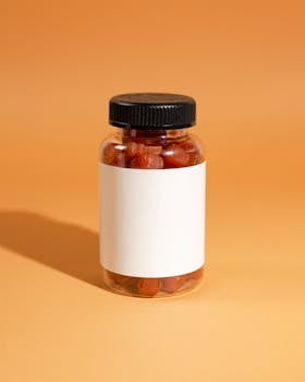 Close-up of a jar filled with red gummies on an orange background, ideal for supplement advertising.