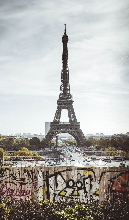 Free Vertical shot of the iconic Eiffel Tower in Paris with graffiti in the foreground. Stock Photo