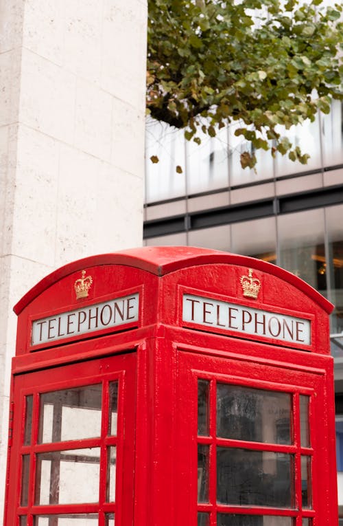 Red Telephone Booth Near White Building