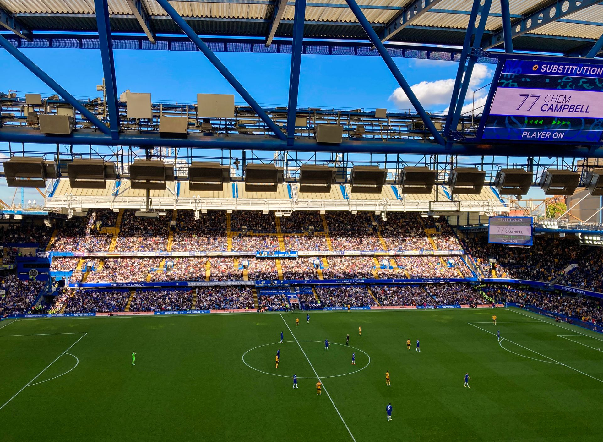People watchng Athletes play Football on a Stadium