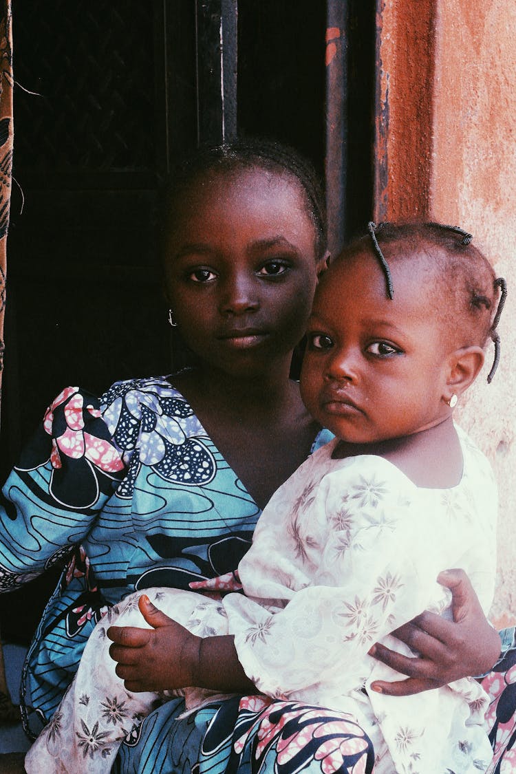 A Girl Holding The Baby On Her Lap 