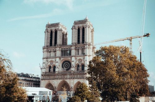 View of the iconic Notre Dame Cathedral in Paris during restoration work with cranes visible.