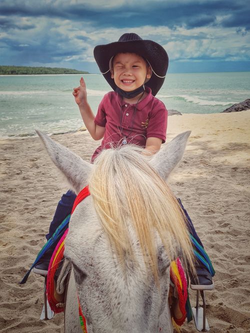 Free Cowboy riding white horse at the beach Stock Photo