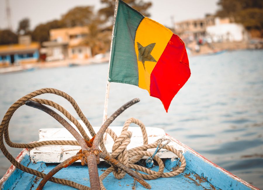 Colorful Senegalese flag and nautical ropes on a boat deck, perfect for travel themes.