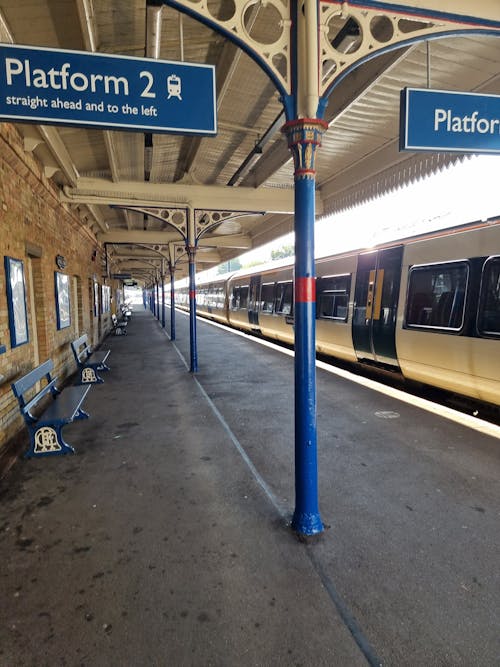Foto profissional grátis de assentos, estação de trem, placa de orientação