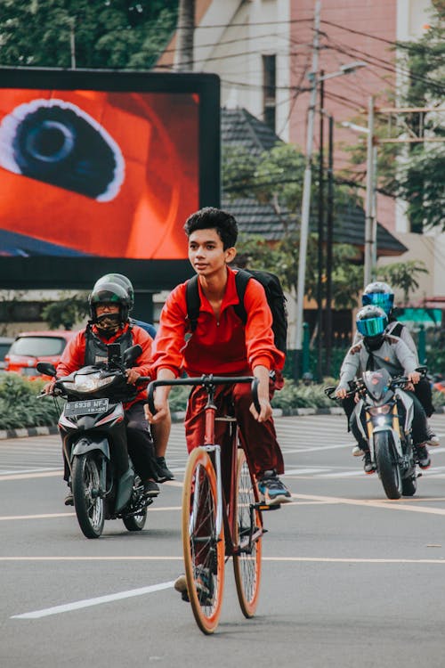 A Boy Riding a Bicycle on a Road 