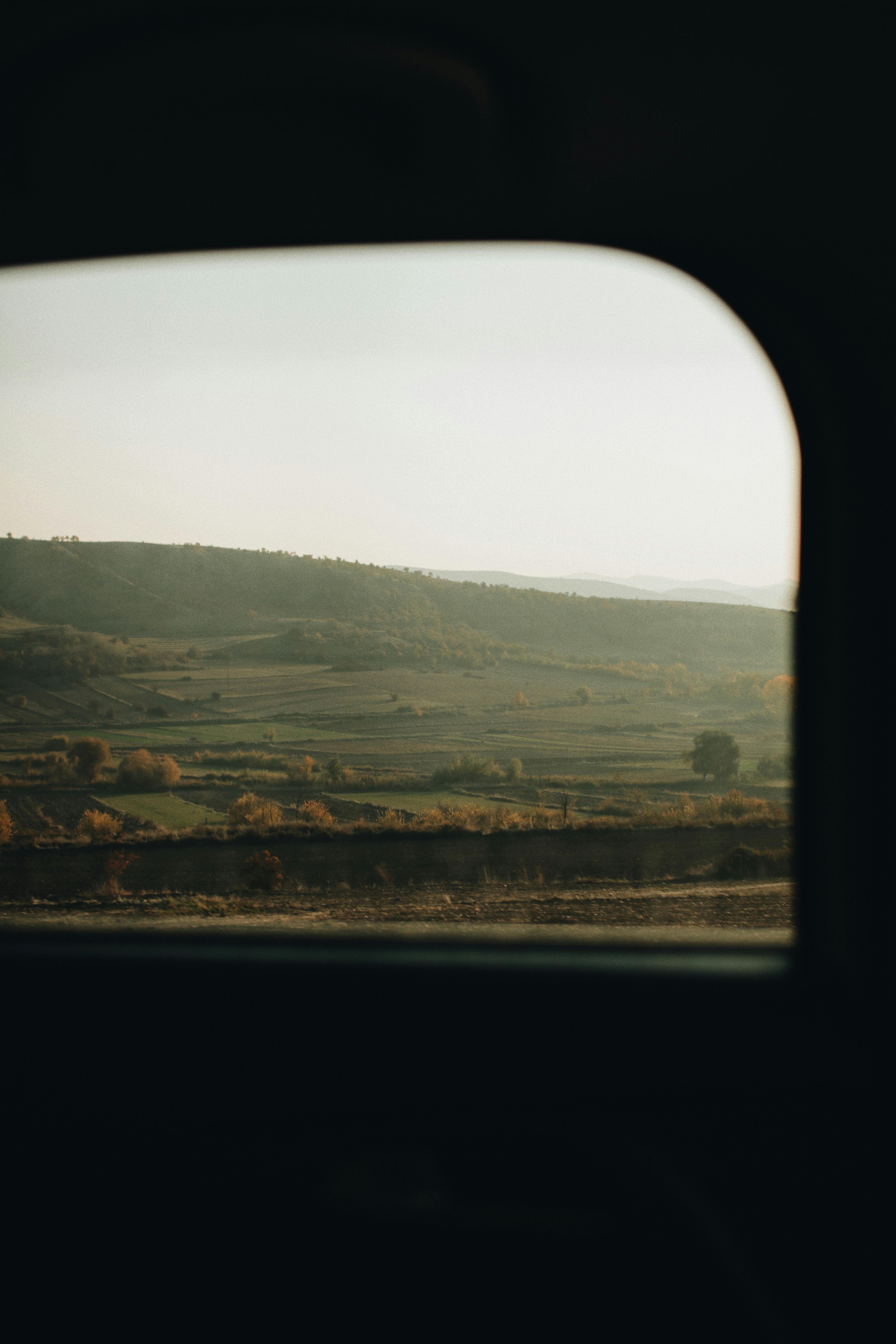 Peaceful countryside landscape seen from a vehicle window during a calm journey.