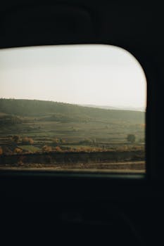 Peaceful countryside landscape seen from a vehicle window during a calm journey.