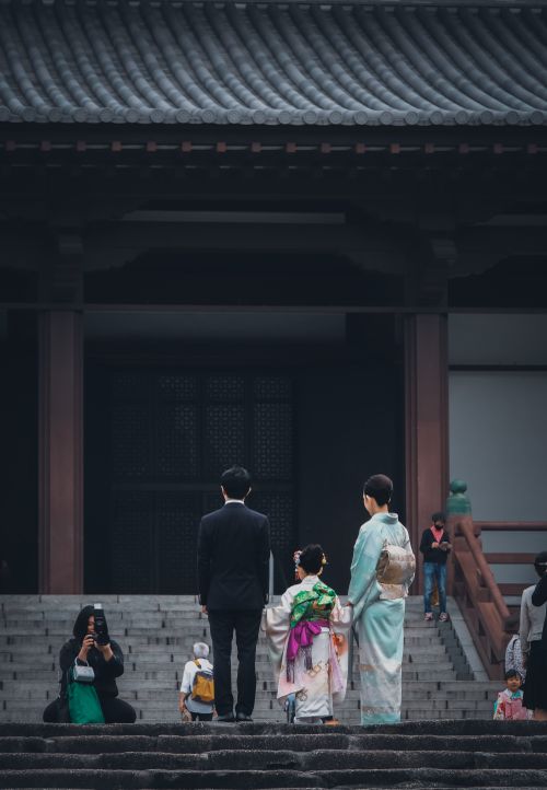Free A family wearing kimonos stands before a traditional temple in Tokyo, Japan. Stock Photo