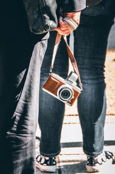A person holding a vintage camera on the streets of Japan, capturing the essence of urban life.