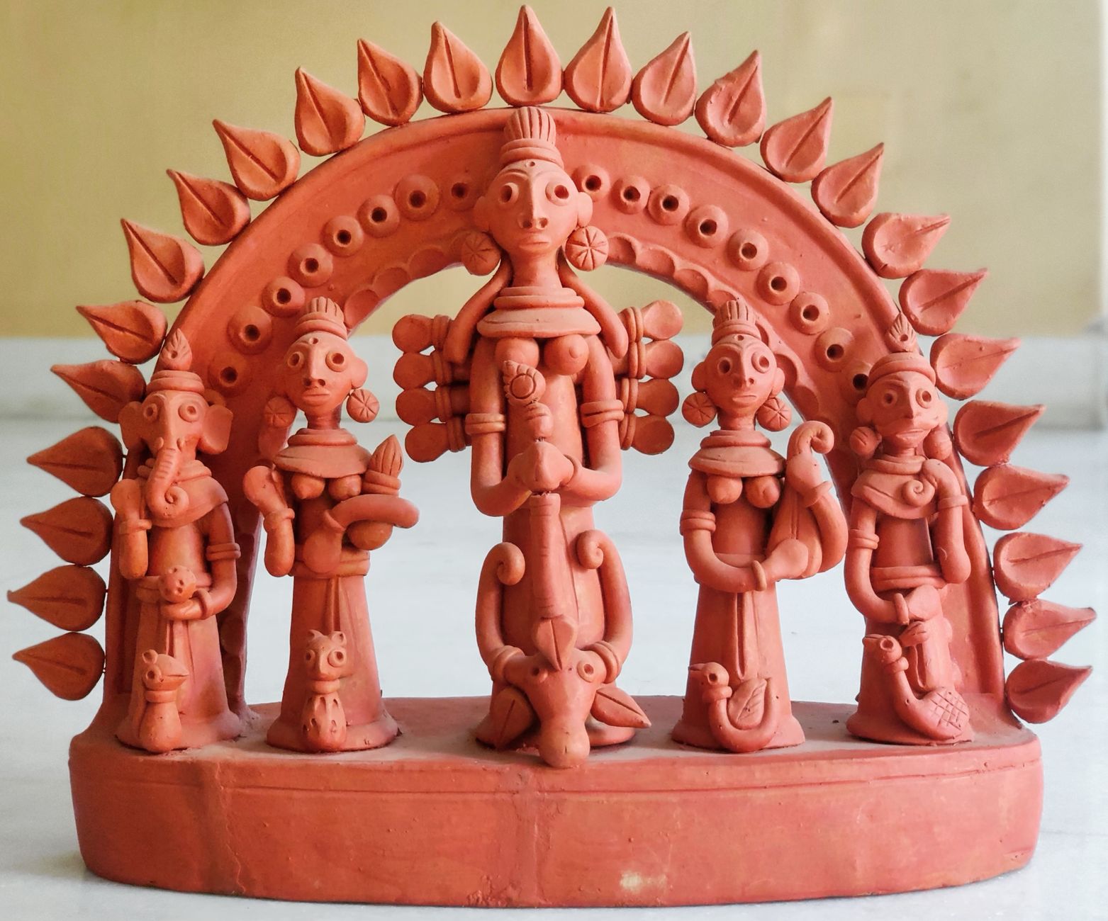 A close-up of an intricate terracotta sculpture depicting multiple figures with artistic details.