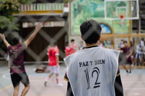 Free Young athletes playing basketball outdoors in Guayaquil, Ecuador, showcasing teamwork and sportsmanship. Stock Photo