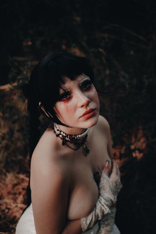 Woman in Halloween Makeup Posing in a Forest 