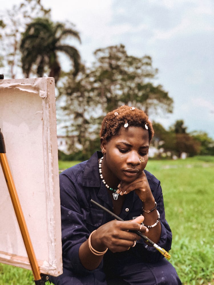 Woman Painting On Canvas Outdoors 