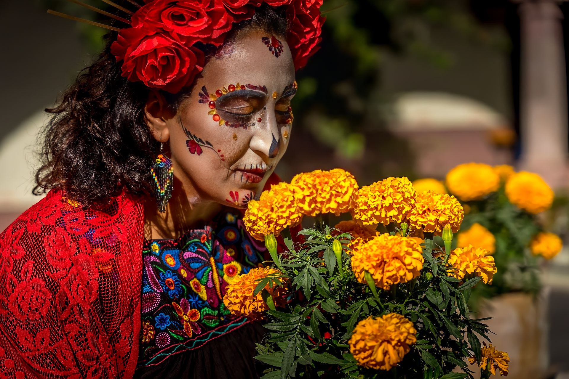Woman with Day of the Dead face paint among marigolds in San Miguel de Allende, Mexico.