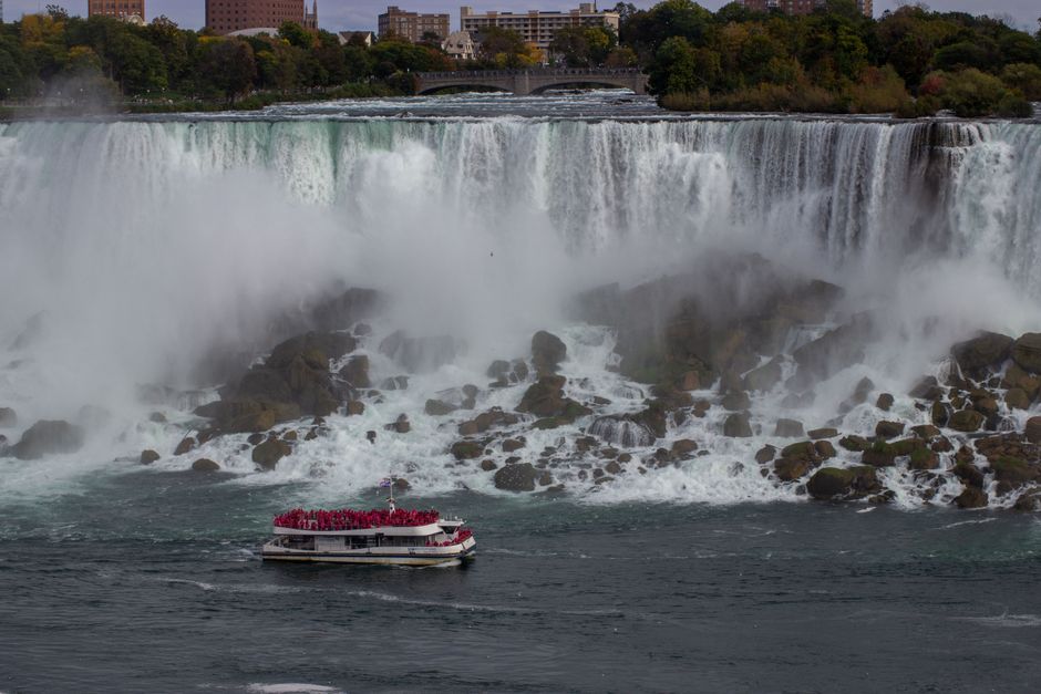 NF USA - Luxury Helicopter Tour with Maid of the Mist & Lunch - A boat navigates near the rushing waters of Niagara Falls, an iconic tourist destination.