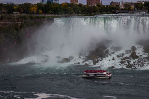A boat full of tourists near the stunning Niagara Falls, Ontario, Canada.