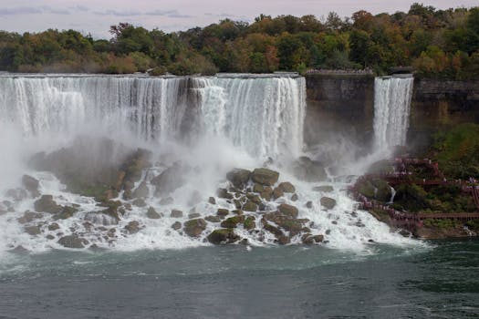 Stunning view of Niagara Falls surrounded by fall foliage and misty waters in Ontario, Canada.