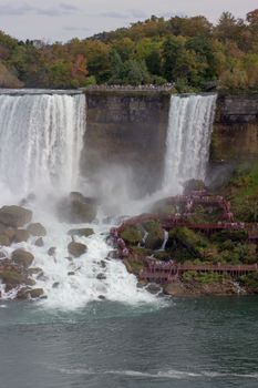 Stunning autumn view of Niagara Falls with cascading waterfalls and vibrant foliage.