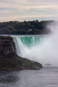 Captivating scene of Niagara Falls with mist and lush surroundings in Ontario, Canada.