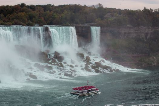 Majestic view of Niagara Falls with a tour boat in the foreground, capturing the natural beauty.