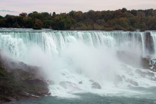 Breathtaking view of Niagara Falls surrounded by autumn foliage and mist.