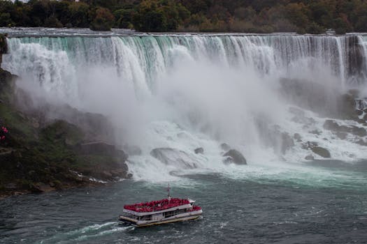 A breathtaking view of Niagara Falls with a crowded tour boat navigating close to the majestic waterfall.
