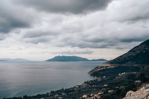 Clouds over Sea Shore with Forest and Village