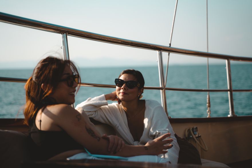 Two women talking on a yacht deck at sea, photo by Enrique on Pexels