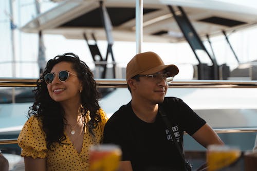 A happy couple enjoying a sunny day on a yacht, embracing leisure and fun.