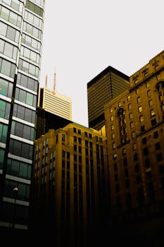 Low angle shot of skyscrapers in a city center, showcasing diverse architectural styles.