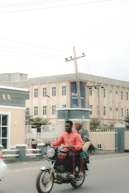 Man Carrying an Elderly Woman on a Motorcycle