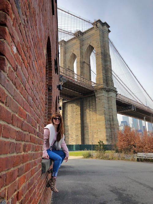 Free A Woman Sitting near the Brooklyn Bridge in New York Stock Photo