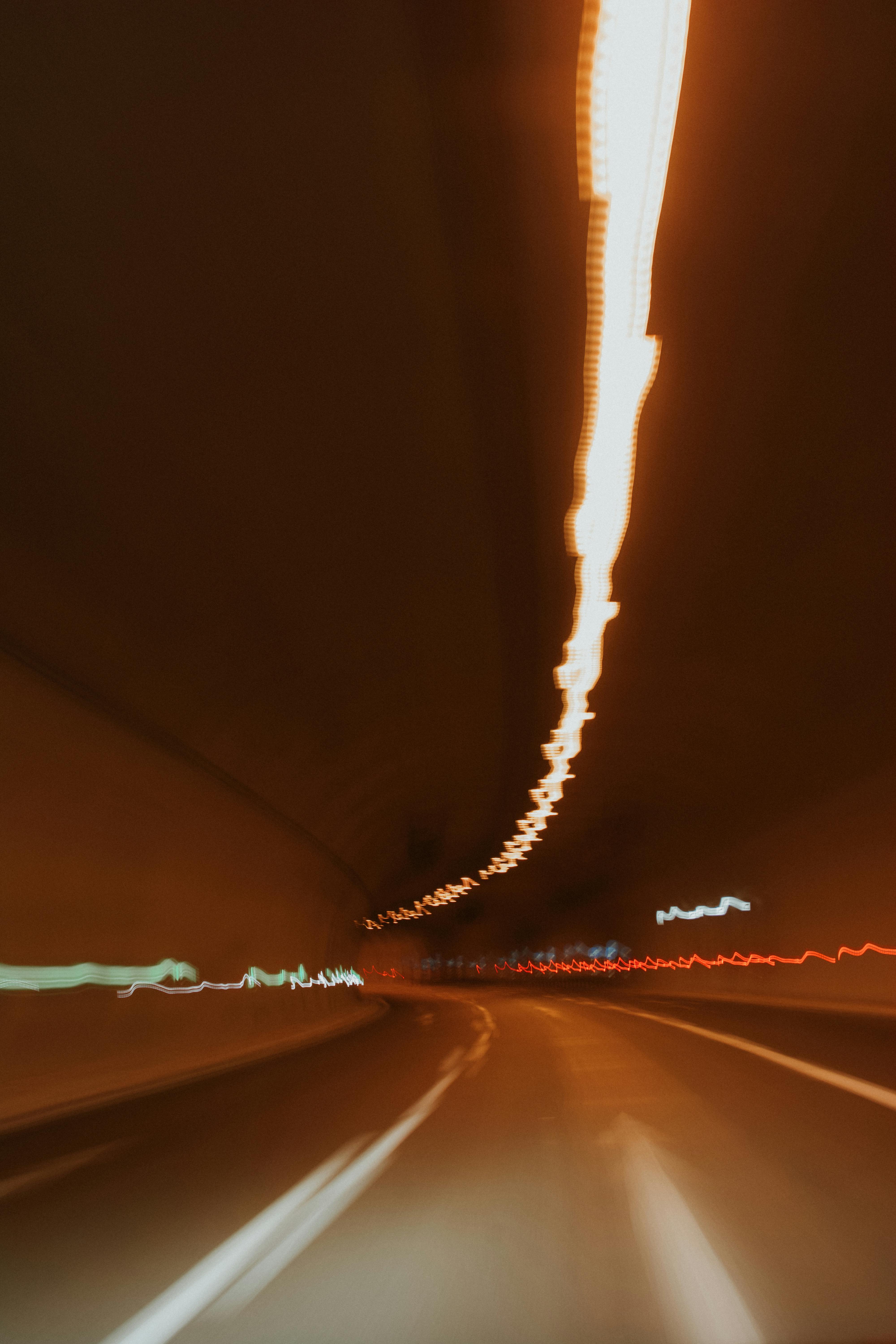 Abstract motion blur with light streaks in a tunnel showcasing dynamic movement.