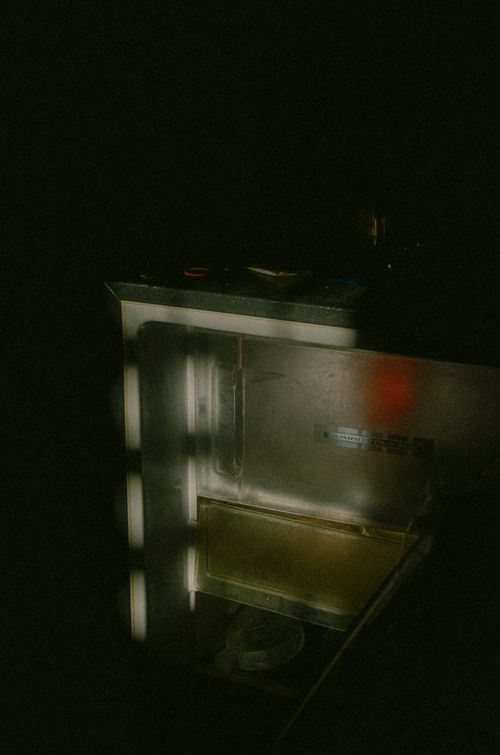 Free A stainless steel fridge stands open in a dimly lit room, casting intriguing shadows. Stock Photo