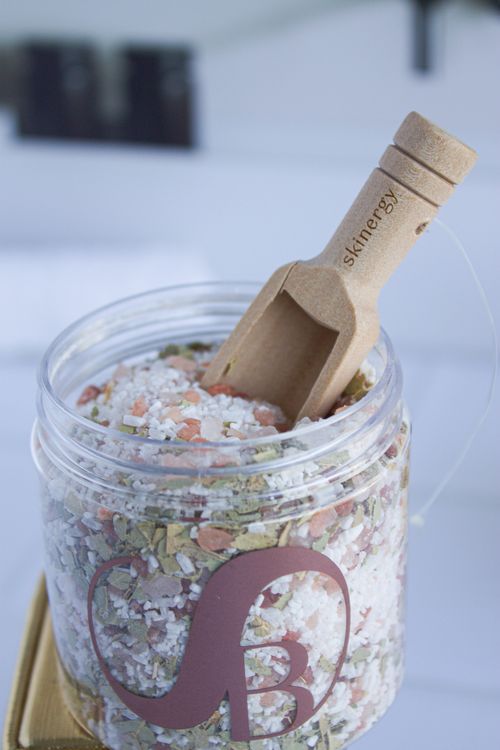 Free Close-up of natural bath salt in a plastic container with a wooden scoop, ideal for relaxation and skincare. Stock Photo