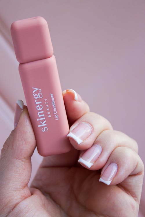 Woman Holding Skinergy Lip Conditioner 
