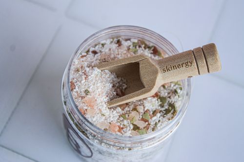 Free A natural skincare salt jar featuring an eco-friendly wooden scoop labeled 'skinergy'. Stock Photo