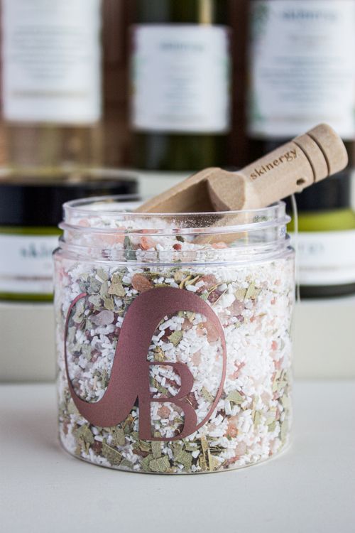 Free A jar of aromatic bath salts with a branded logo and wooden scoop, perfect for spa and relaxation themes. Stock Photo