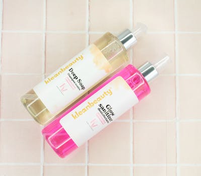 Close-up of branded soap and sanitizer bottles on a minimalist grid background.