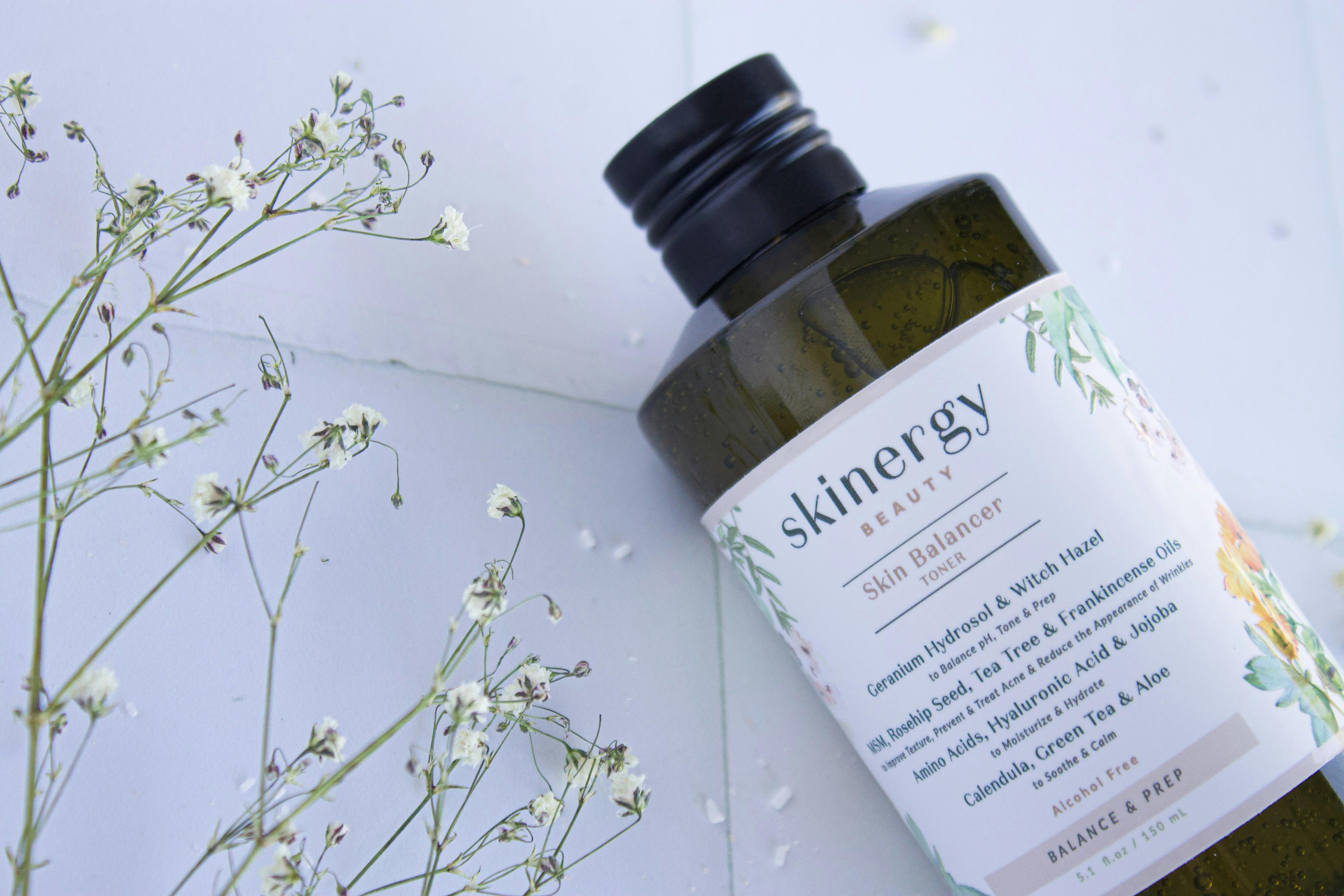 Bottle of witch hazel toner with witch hazel leaves in the background, emphasizing natural ingredients