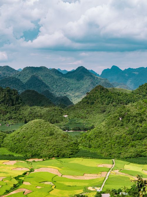 Free A picturesque view of green rice fields and mountains under a clouded sky in Hà Giang, Vietnam. Stock Photo