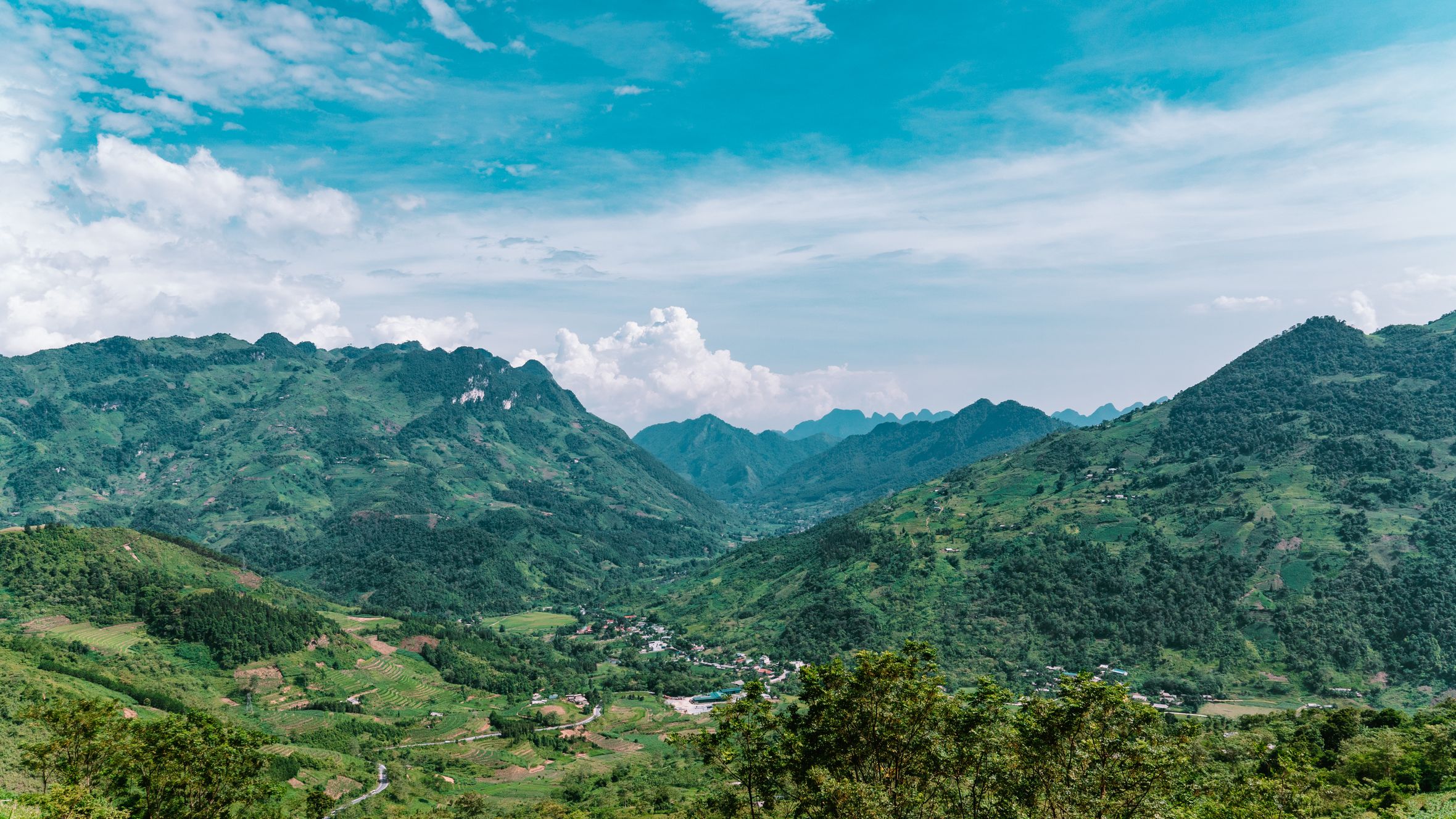 Experience the lush green landscapes and stunning mountains of Hà Giang, Vietnam captured from above.