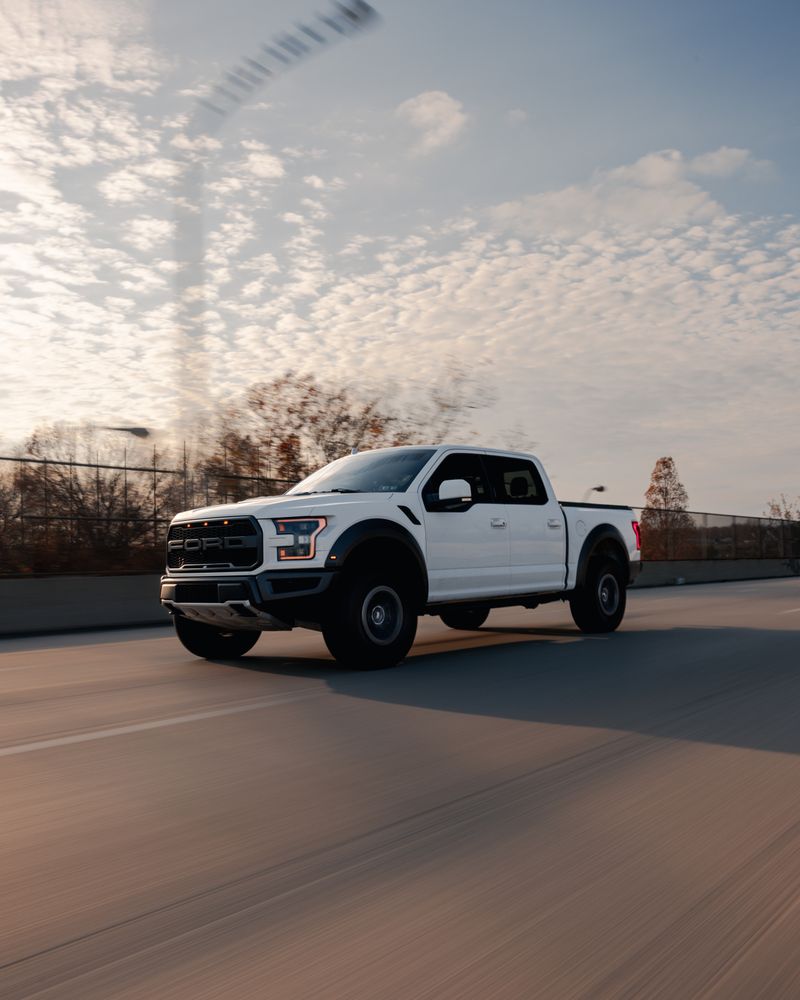 White used pickup truck driving on the road